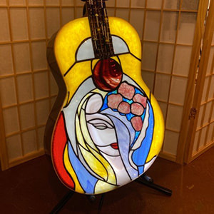 Stained glass lamp in the shape of an acoustic guitar